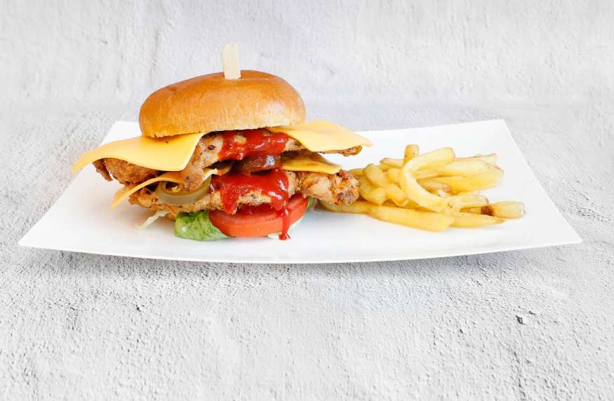 The Burgerzzz double-fried chicken burger with cheese, ketchup, jalapenos, tomato, and fries.